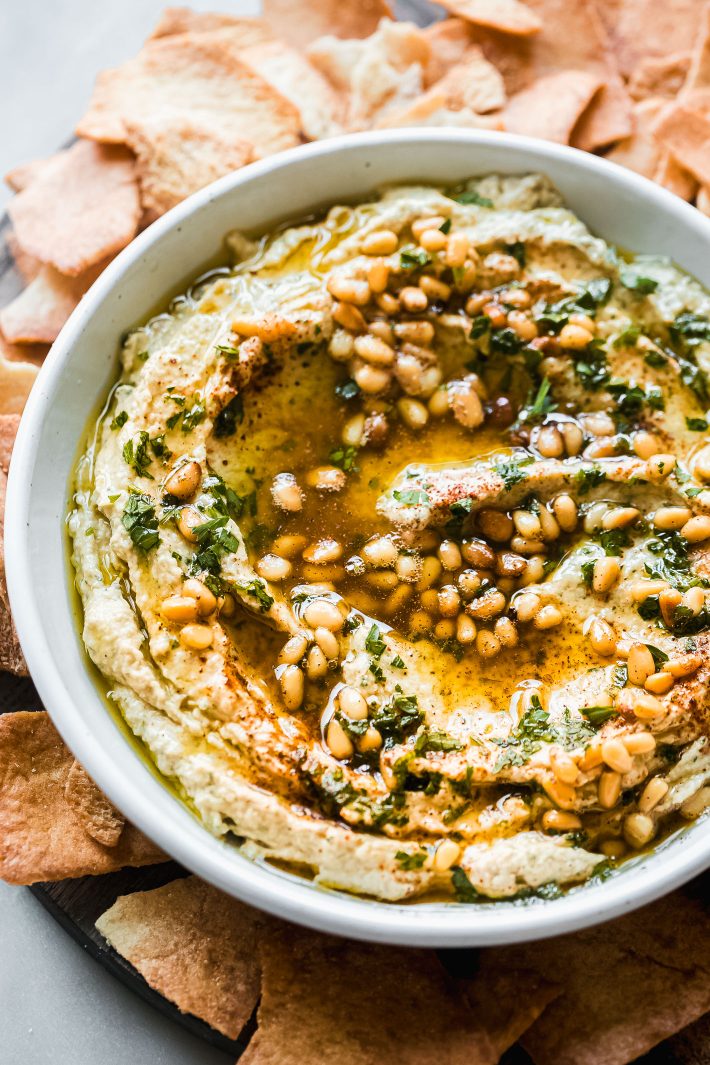 creamy hummus topped with pine nuts and olive oil